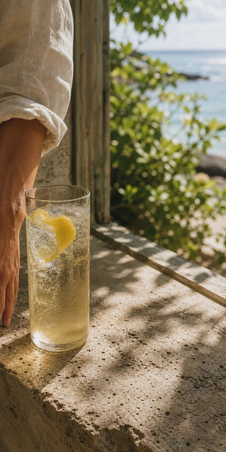 A cold sparkling yuzu drink beside an open window overlooking the ocean